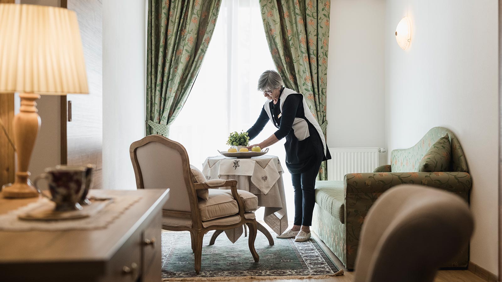 Eine Kellnerin arrangiert eine Pflanze in einem der Zimmer des Hotels Laguscei