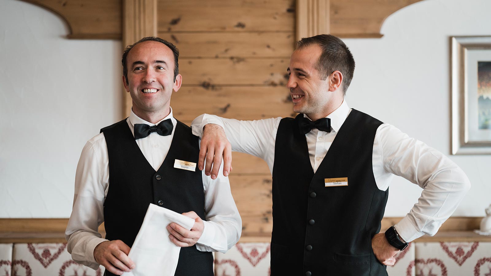 Zwei Kellner lächelnd im Speisesaal des Hotels Laguscei
