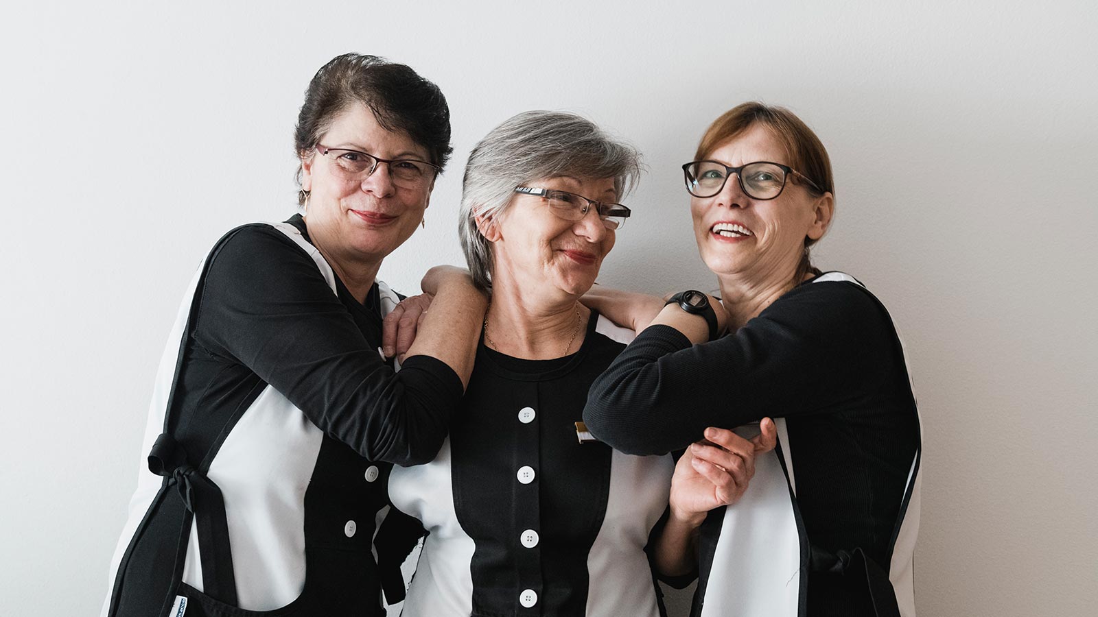 Three waitresses on the floors of the Hotel Laguscei smiling