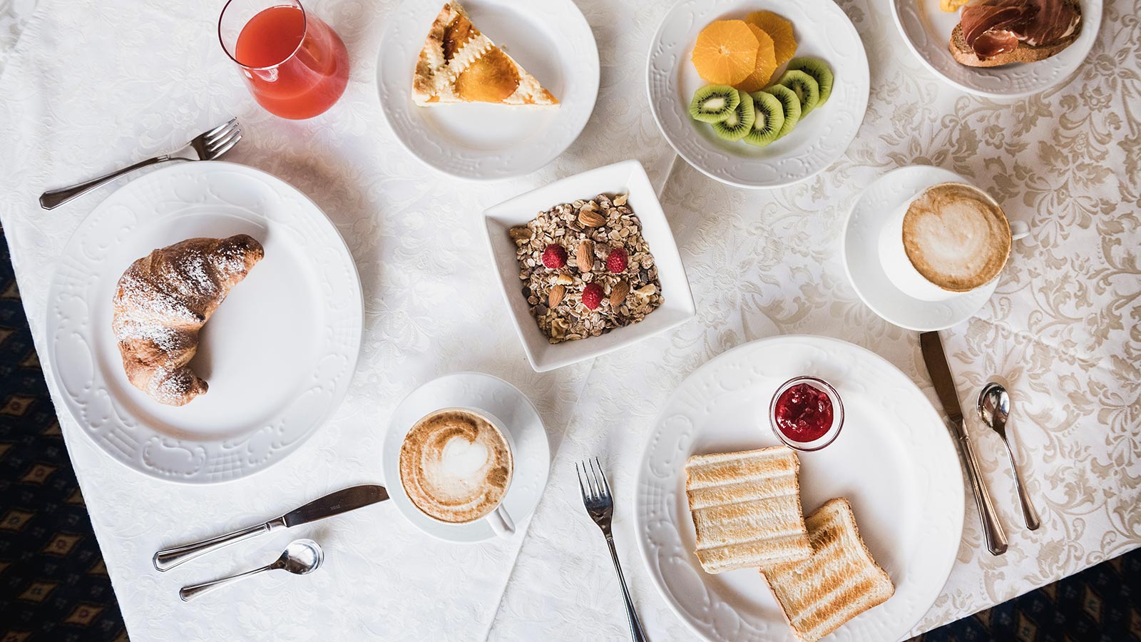 Una gustosa colazione con frutta, brioche, muesli, crostate e capuccino presso l'Hotel Laguscei